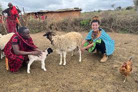 A volunteer meeting local families and livestock during a rural community visit.